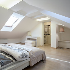 View of a bright, contemporary loft conversion featuring multiple roof windows
