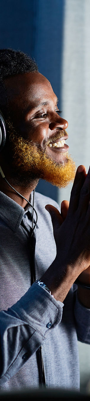 Man with headphones recording vocals in a studio
