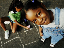 Kids playing hop scotch.
