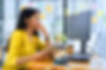 A woman thinking in front of computer screens