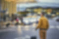 A man standing on the street outside an airport with luggage