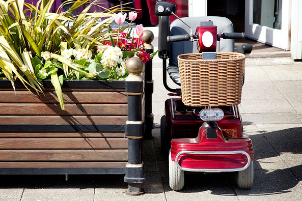 Red mobility scooter parked in a town centre ready for convenient local travel