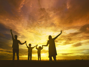 Silhouette einer vierköpfigen Familie mit erhobenen Händen vor einem dramatischen, golden leuchtenden Abendhimmel als Symbol für Gemeinschaft und Anbetung.