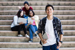 A male student holding a notebook