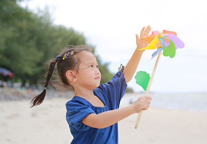 Smiling Asian girl playing pinwheel
