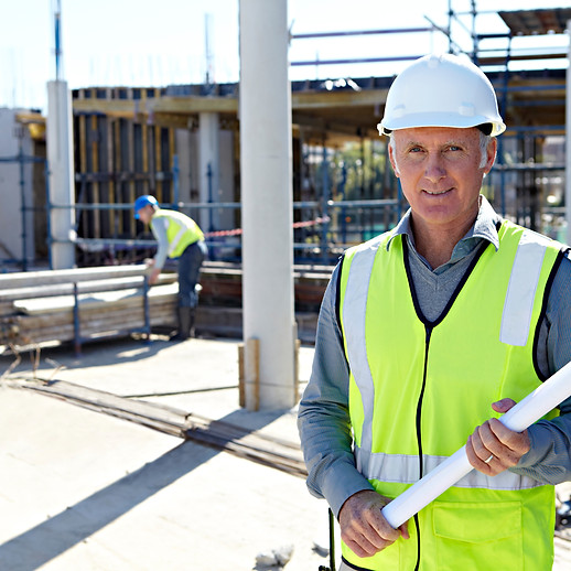 Portrait of an architect, aged 52, on the building site of a new office complex