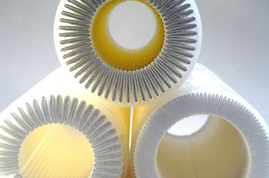 A close-up view of several cylindrical filters with pleated interiors.