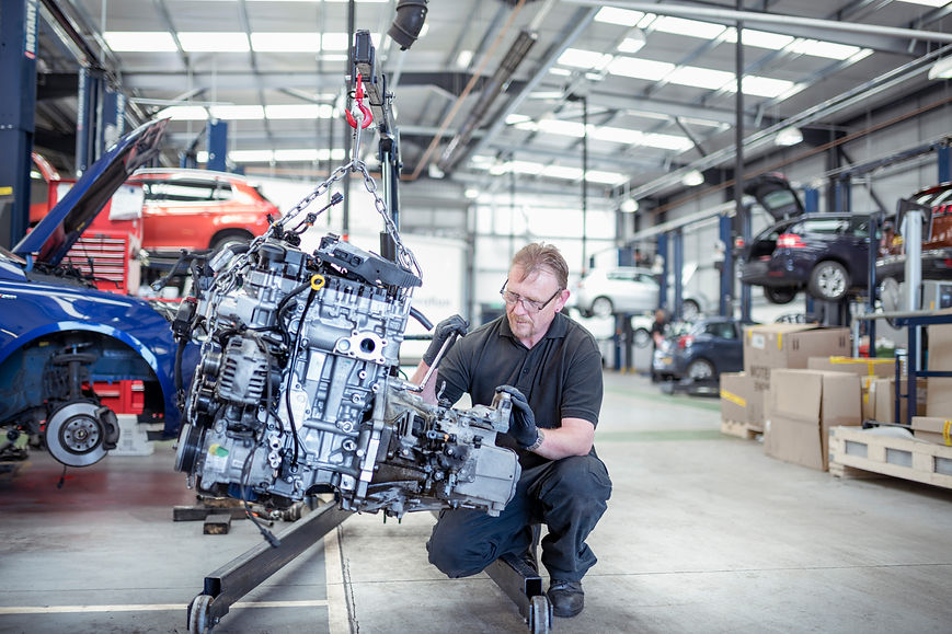 Engineer with car engine in car service centre