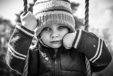 Little girl sitting on a swing looking lost/sad