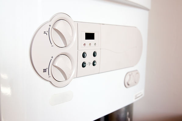 White boiler control panel with two large knobs and several buttons