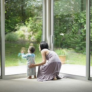 Mother and son looking out window