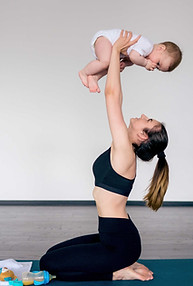 Active woman holding baby in the air
