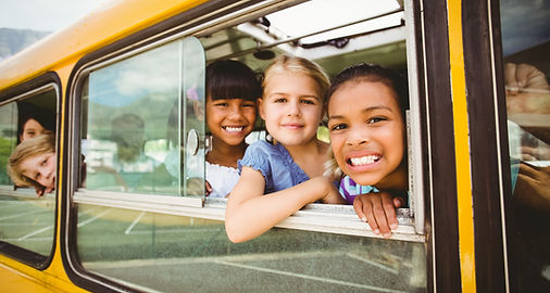 children looking out the windsor of a school bus