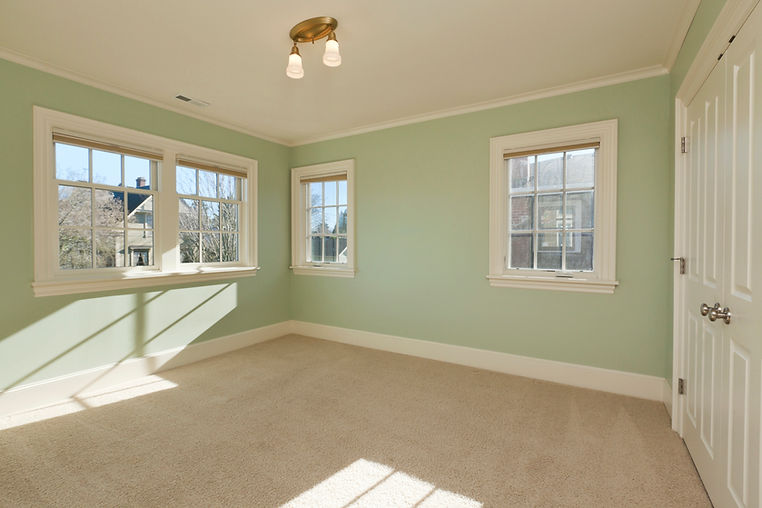 Empty room with light green walls and beige carpet
