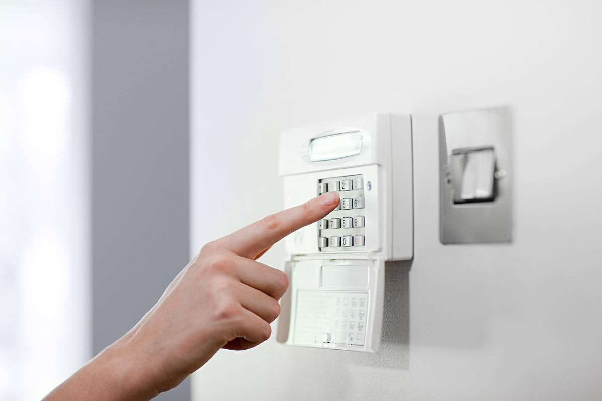 Woman setting burglar alarm