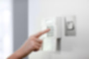 Woman setting burglar alarm