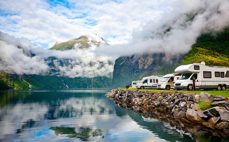 Several models of RVs lined up in front of a mountainous landscape