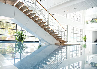 Modern interior with a sleek wooden staircase and glass railings