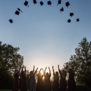 student throwing graduation hats to the air