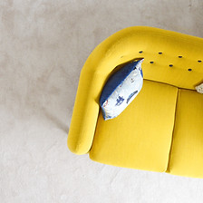 Kissen mit traurigem Smiley auf der Couch als Symbol für Schlafprobleme