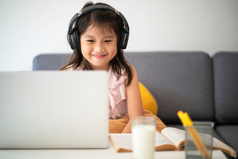 A young girl enjoys her learning session using Fast ForWord, a software to help overcome reading difficulties that is accessible through The Key Clinic.