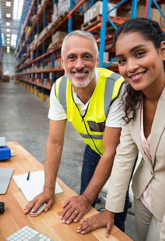 Warehouse staff managing logistics operations at computer workstation