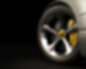 Close-up of a polished silver car wheel with a yellow brake calliper