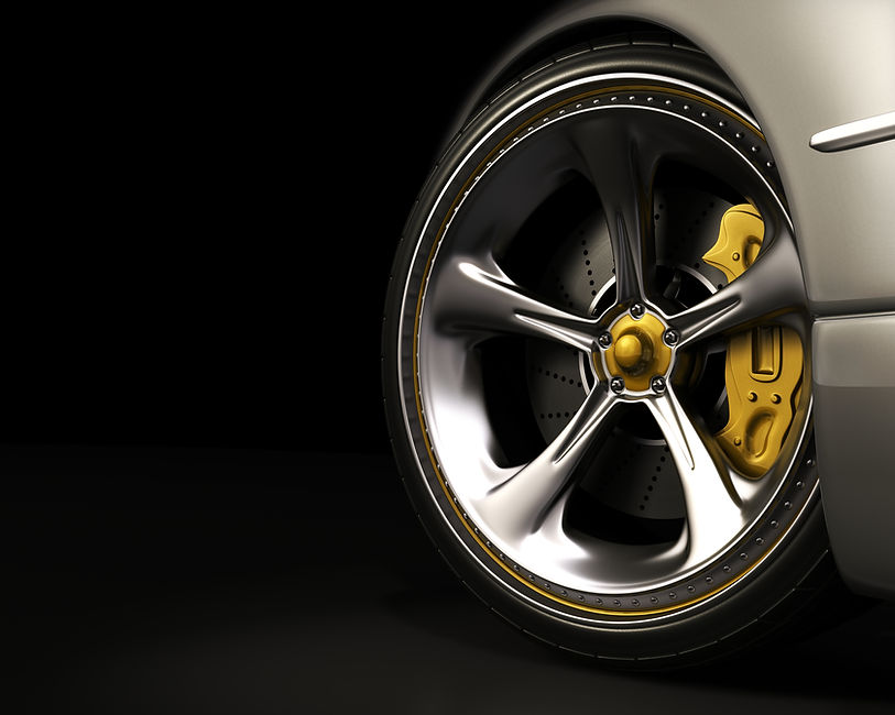 Close-up of a polished silver car wheel with a yellow brake calliper