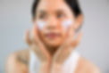 Asian woman applying skincare
