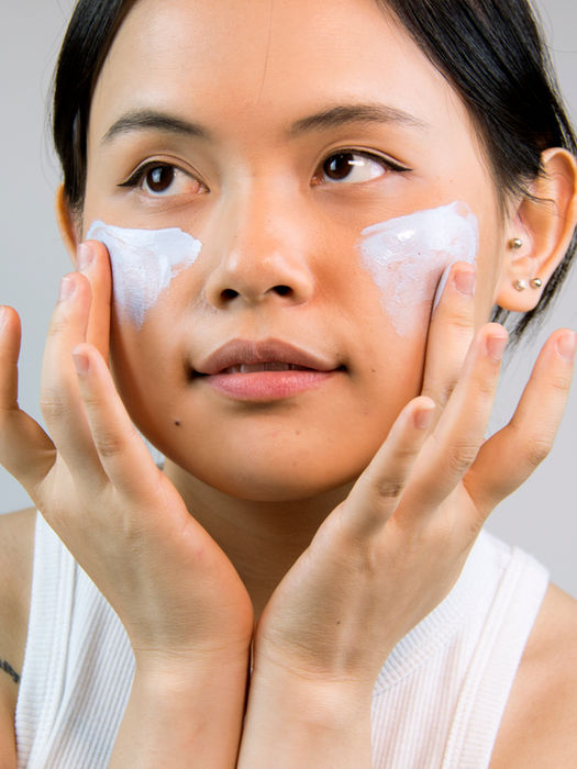 Woman applying facial cream