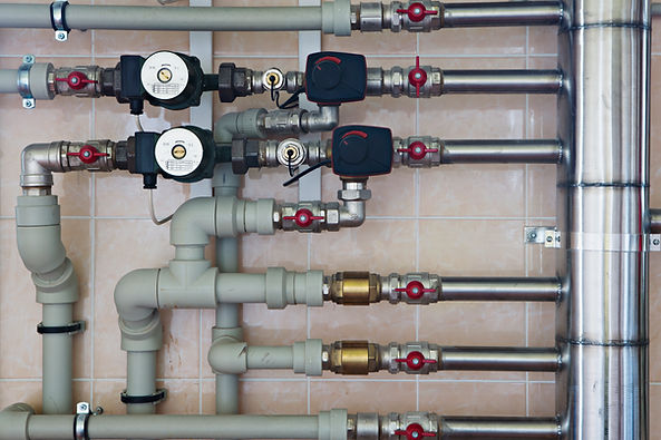Underfloor heating manifold with white control valves and flow meters for home heating system