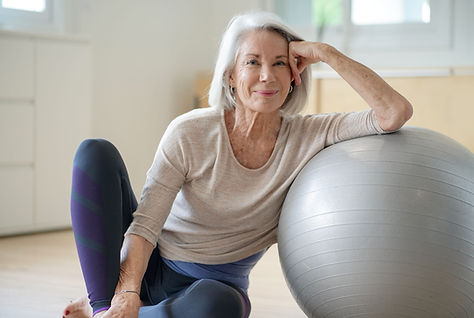 Persona appoggiata sulla palla da ginnastica