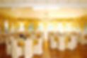 A spacious room filled with tables and chairs for gatherings and meetings.