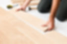 Close up of a flooring specialist installing light wood planks in Rochester