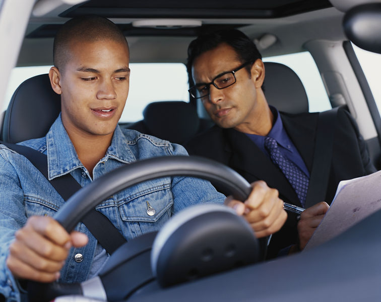 Driving instructor observing learner driver