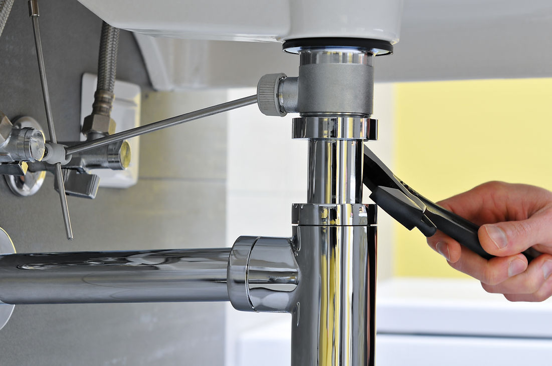 Close-up of plumber's hand while using a tool to repair sink pipe