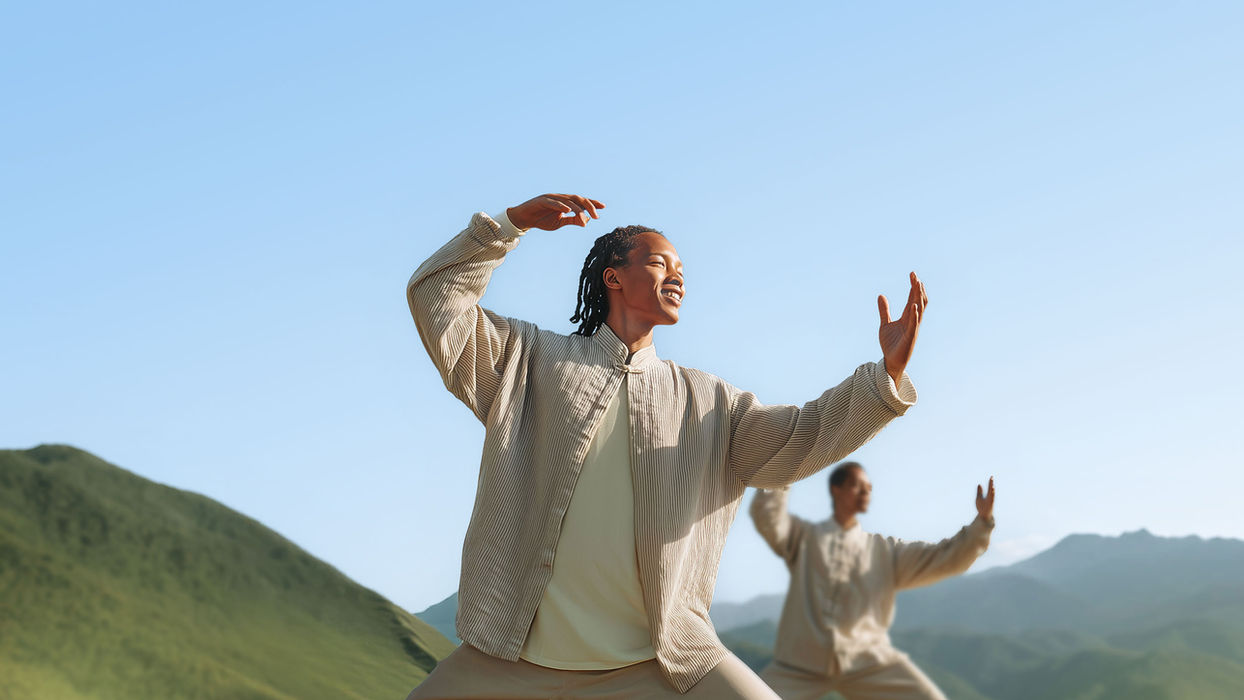 Persona practicando Tai-Chi con movimientos suaves y meditativos en un ambiente tranquilo.