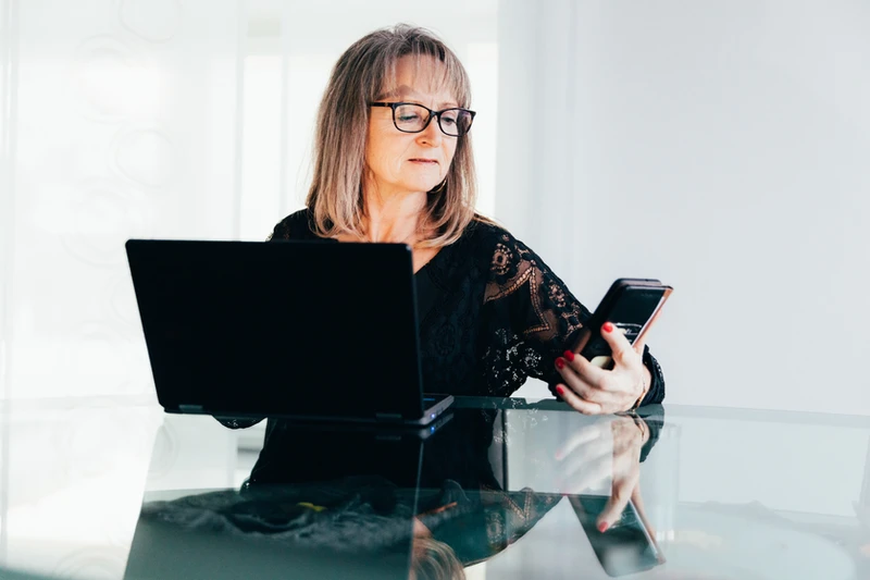 woman holding phone and computer tablet