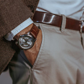 man wearing a watch with his hand in his pocket, wearing a belt