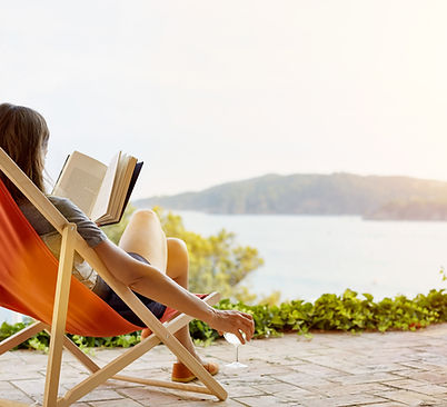 Femme qui lit un livre sur une chaise longue
