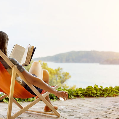Une femme lit un livre sur une chaise longue