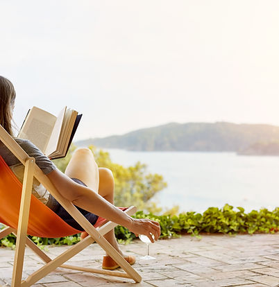 Une femme lit un livre sur une chaise longue