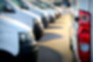 A large group of delivery vans / transporters after work in a parking lot at sunset. The f