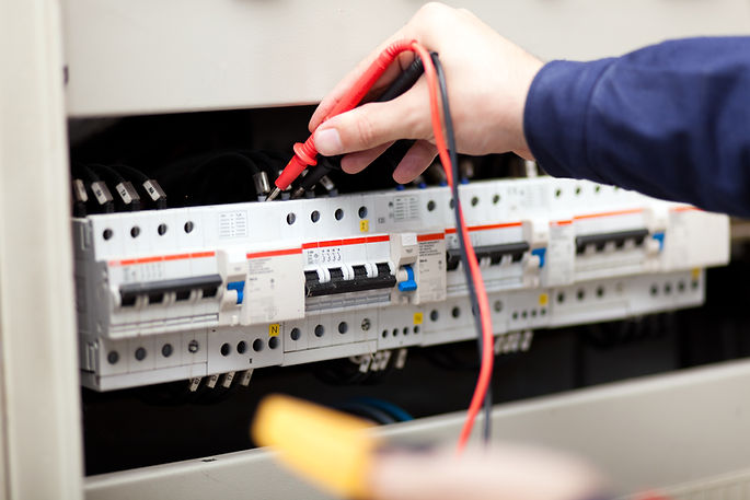 Electrician using diagnostic probes to test a modern consumer unit for safe electrical installations in Crawley