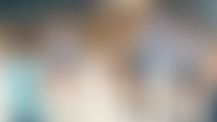 Children enjoying gross motor activities as they play jump rope together on a sunny playground, with one girl jumping while others watch nearby.