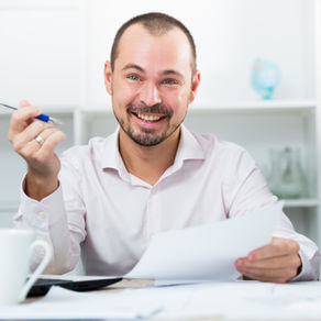 Smiling man doing paperwork.