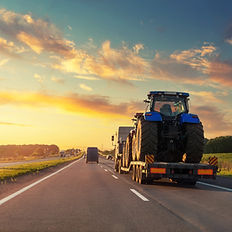 truck hauling a tractor on the highway