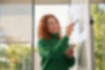 Woman with curly hair pointing at a whiteboard