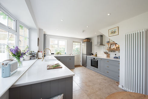 A general interior view of a shaker style kitchen with grey fitted cabinets, units within