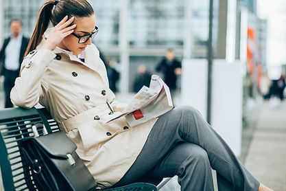Femme lisant un journal sur un quai de gare